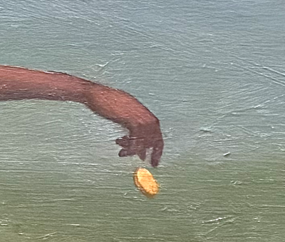 Woman's hands holding a gold coin and a photograph