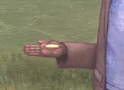 Man's hand holding a gold coin in his palm